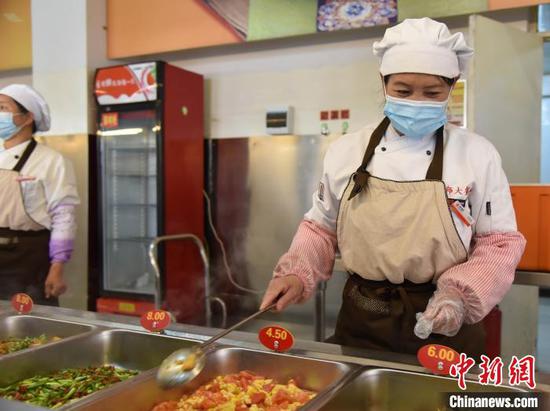 图为学校食堂为学生准备安全营养餐。　张玮